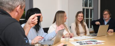 Staff smiling and talking around a meeting room table