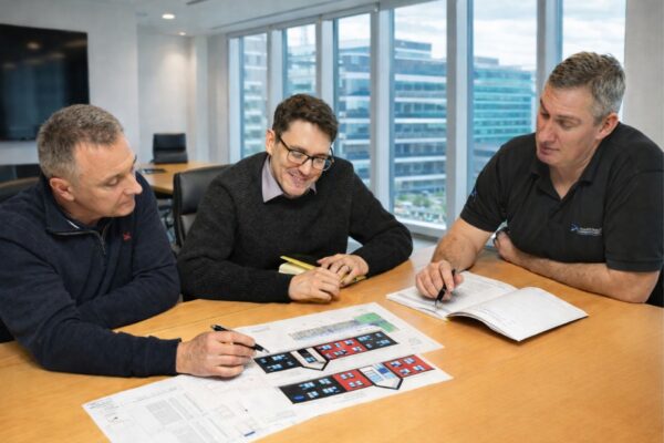 Staff looking at plans and drawings on a meeting room table